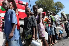 Người dân Haiti chờ nhận nước sạch sau động đất tại thủ đô Port au Prince ngày 14/1. (Ảnh: AFP/TTXVN)