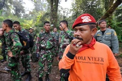 Binh sỹ và các thành viên đội cứu hộ Indonesia tìm kiếm vị trí máy bay rơi tại vùng núi Cidahu. (Nguồn: AFP/TTXVN)