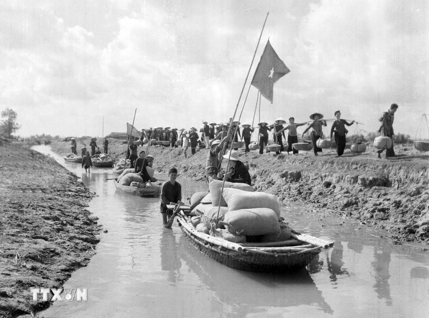 Giai đoạn 1960-1975, dưới sự lãnh đạo của Đảng, quân và dân ta vừa xây dựng chủ nghĩa xã hội (CNXH) ở miền Bắc, vừa chiến đấu đánh thắng cuộc chiến tranh xâm lược kiểu mới của đế quốc Mỹ. Trong ảnh: Nông dân Thái Bình vận chuyển thóc đến đóng thuế cho nhà nước tại tổng kho thị xã Hòa Bình (12/1960). (Ảnh: Văn Thái/TTXVN)