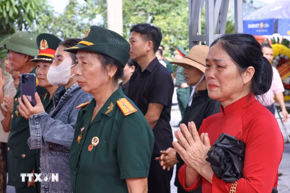 Tình cảm của người dân khi chứng kiến lễ các hài cốt liệt sỹ được quy tập về Nghĩa trang liệt sỹ Quốc gia Vị Xuyên, sẵn sàng cho lễ truy điệu và an táng chiều 26/7. (Ảnh: Hoàng Hiếu/TTXVN)