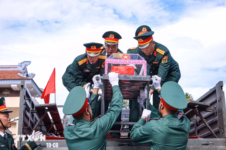 Di chuyển hài cốt liệt sỹ từ xe xuống Nghĩa trang liệt sỹ Quốc gia Vị Xuyên. (Ảnh: Hoàng Hiếu/TTXVN)