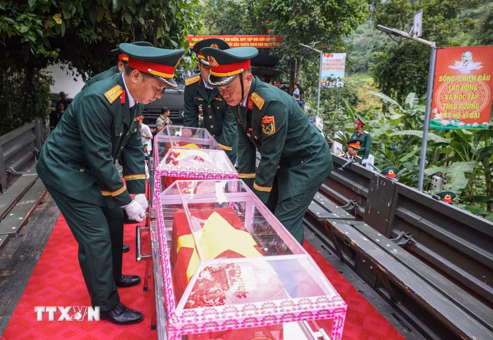 Đưa hài cốt 34 liệt sỹ di từ nhà chờ Đội tìm kiếm, quy tập hài cốt liệt sỹ tỉnh Tuyên Quang lên xe để di chuyển về Nghĩa trang liệt sỹ Quốc gia Vị Xuyên. (Ảnh: Hoàng Hiếu/TTXVN)