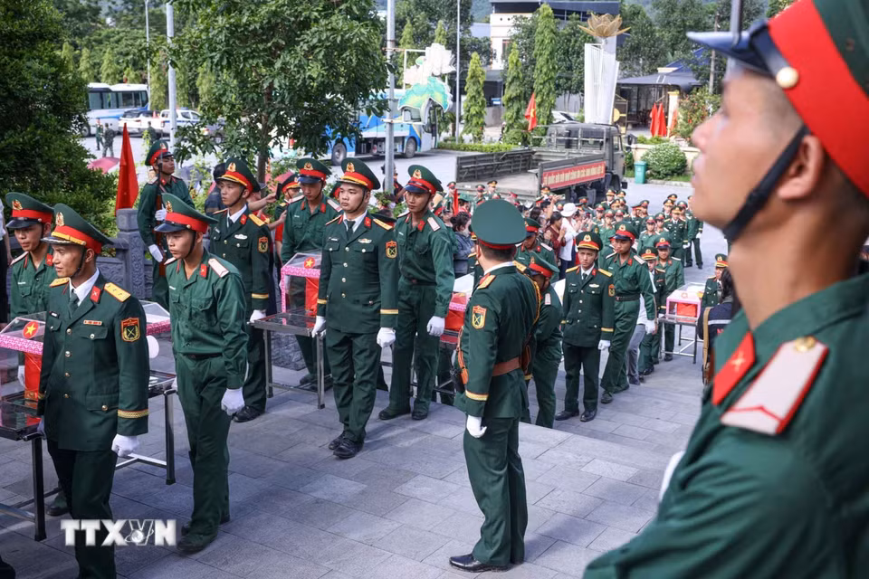 Di chuyển hài cốt liệt sỹ từ xe xuống Nghĩa trang liệt sỹ Quốc gia Vị Xuyên. (Ảnh: Hoàng Hiếu/TTXVN)
