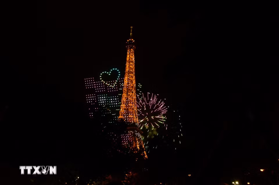 Các thiết bị bay không người lái (drone) tạo hình trên bầu trời, cạnh Tháp Eiffel trong chương trình trình diễn ánh sáng chào mừng Quốc khánh Pháp tại Paris tối 13/7/2026. (Ảnh: Hữu Chiến/TTXVN)