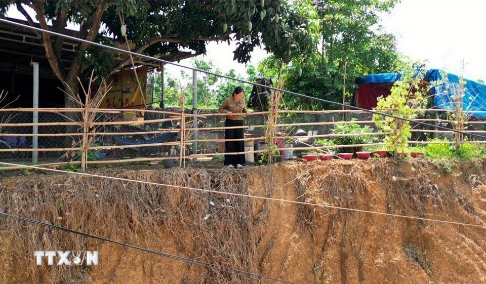 Gia đình chị Nguyễn Thị Nguyệt tại xã Phú Riềng (Đồng Nai) phải làm 2 lớp hàng rào ngăn cách với mép vực để bảo đảm an toàn. (Ảnh: Đậu Tất Thành/TTXVN)