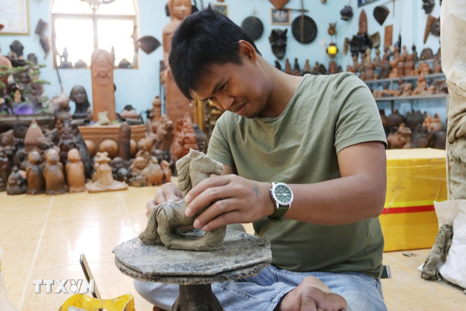 Thợ gốm Hợp tác xã gốm Chăm Bàu Trúc (xã Ninh Phước, tỉnh Khánh Hòa) tạo hình linh vật ngựa bằng phương pháp thủ công truyền thống. (Ảnh: Nguyễn Thành/TTXVN)