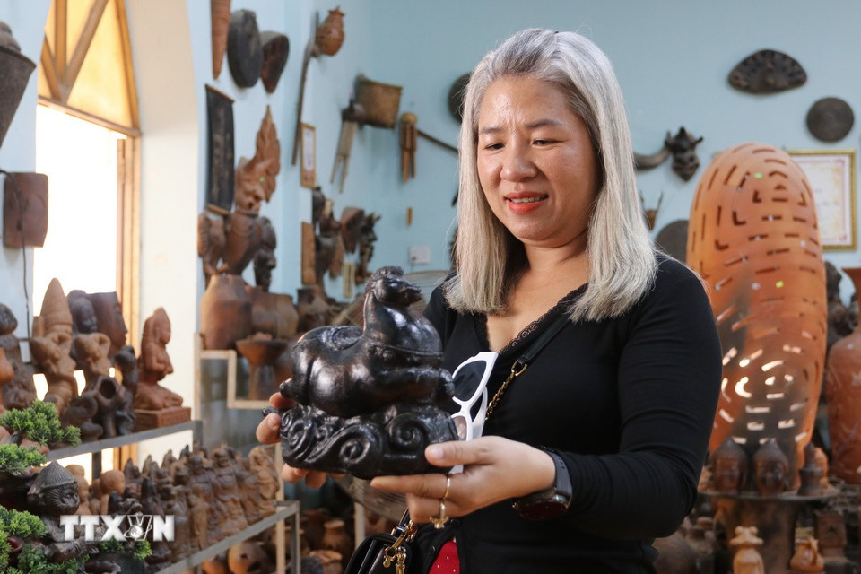 Khách hàng lựa chọn linh vật ngựa gốm của Hợp tác xã gốm Chăm Bàu Trúc (xã Ninh Phước, Khánh Hòa). (Ảnh: Nguyễn Thành/TTXVN)