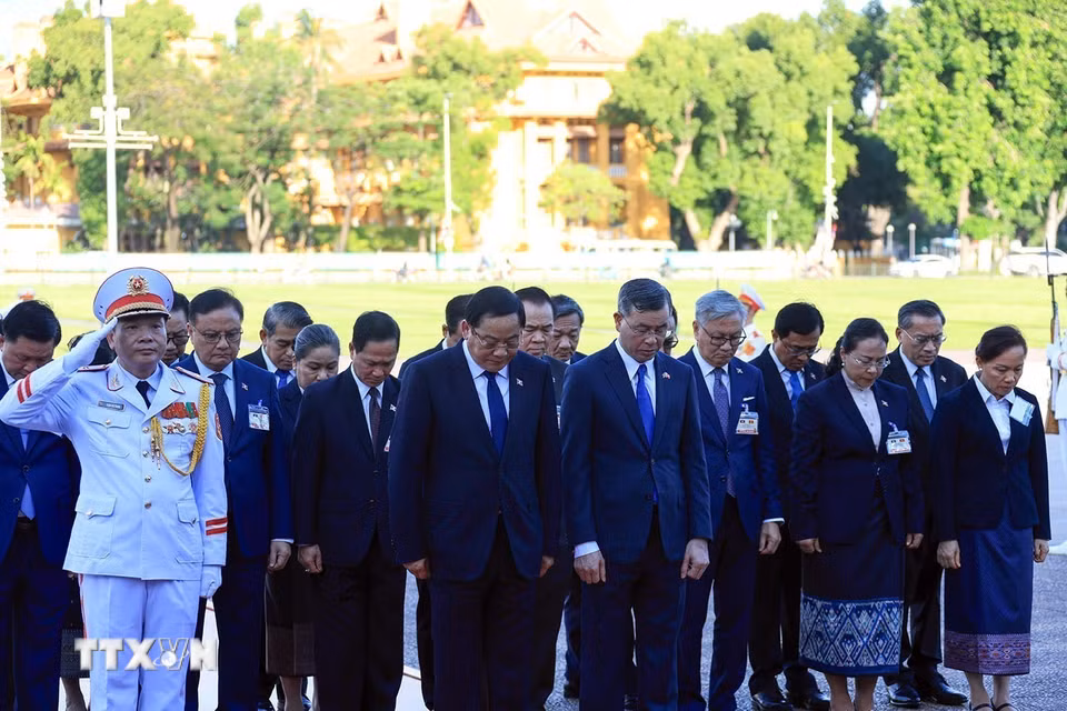 Thủ tướng Lào Sonexay Siphandone và các đại biểu kính cẩn tưởng niệm Chủ tịch Hồ Chí Minh. (Ảnh: Tuấn Anh/TTXVN) ​