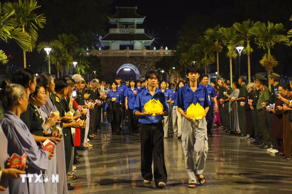 Đoàn viên thanh niên rước hoa đăng vào Nghĩa trang Liệt sỹ A1. (Ảnh: Xuân Tư/TTXVN)