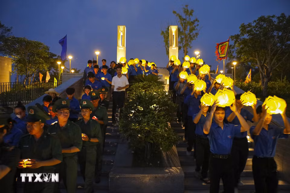 Đoàn viên thanh niên rước hoa đăng từ Đền thờ liệt sỹ Chiến trường Điện Biên Phủ xuống Nghĩa trang Liệt sỹ A1. (Ảnh: Xuân Tư/TTXVN)