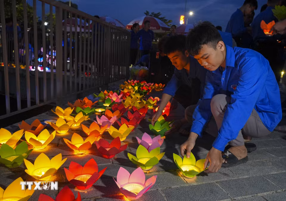 Đoàn viên thanh niên chuẩn bị hoa đăng để thả xuống dòng sông Nậm Rốm. (Ảnh: Xuân Tư/TTXVN)