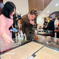 Chuyên gia quốc tế chiêm ngưỡng một số Châu bản triều Nguyễn. (Ảnh: Mai Mai/Vietnam+)