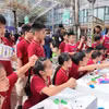 Nhiều học sinh hào hứng tham gia các hoạt động trải nghiệm về an toàn mạng và kỹ năng số tại Lễ phát động chương trình “Bảo vệ và hỗ trợ trẻ em phát triển trên môi trường mạng giai đoạn 2026–2030”. (Ảnh: Hằng Trần/Vietnam+)