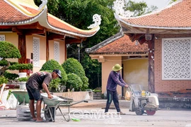 Công nhân tiến hành nâng nền sân sau của Khu lưu niệm. (Nguồn: Báo Cà Mau)