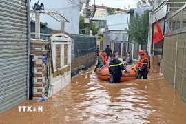 Lực lượng chức năng đưa người ra khỏi các căn nhà ven suối tại khu vực đường Lữ Gia (phường Lâm Viên – Đà Lạt) bị ngập sâu sau trận mưa lớn chiều 12/8. (Ảnh: Nguyễn Dũng/TTXVN)