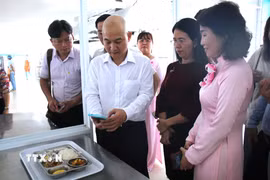 Lãnh đạo Sở Công Thương Thành phố Hồ Chí Minh và đại diện phường Tân Mỹ kiểm tra nguồn gốc thực phẩm từ mã QR tại khay cơm có gắn "Tick xanh trách nhiệm" tại trường Mầm non Phú Mỹ, Thành phố Hồ Chí Minh. (Ảnh: Hương Giang/TTXVN)