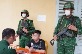 Đối tượng Phạm Châu Dũng thuộc diện truy nã, bị tạm giữ để bàn giao cho các lực lượng chức năng phụ trách xử lý. (Ảnh: TTXVN phát)