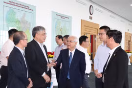 Chủ tịch Ủy ban Nhân dân tỉnh Bình Dương Võ Văn Mình (bên trái) trao đổi với các chuyên gia, nhà khoa học bên lề hội thảo. (Ảnh: Dương Chí Tưởng/TTXVN)