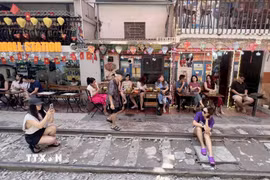 Nhiều du khách nước ngoài tranh thủ "check-in" tại "phố càphê đường tàu" ở Hà Nội, sáng 15/6. (Ảnh: Thành Phương/TTXVN)