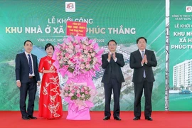 Lãnh đạo tỉnh Vĩnh Phúc tặng hoa cho đại diện Công ty Trách nhiệm Hữu hạn Thương mại và Xây dựng Thân Hà, đơn vị chủ đầu tư Dự án Khu nhà ở xã hội phường Phúc Thắng. (Ảnh: Nguyễn Trọng Lịch/TTXVN)