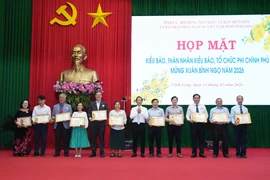 Lãnh đạo Ủy ban Nhân dân tỉnh Vĩnh Long trao Bằng khen cho các tập thể, hộ gia đình đã có thành tích tích cực ủng hộ vật chất xây dựng giao thông nông thôn và thực hiện công tác an sinh xã hội. (Ảnh: Phạm Minh Tuấn/TTXVN)