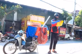 Khi nhiệt độ ngoài trời hơn 40 độ, các shipper vẫn có mặt tại các tuyến phố để giao từng đơn hàng đúng hẹn. (Ảnh: Tuấn Anh/TTXVN)
