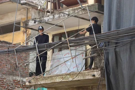 Người dân tự tháo dỡ nhà để bàn giao mặt bằng sạch để thực hiện dự án xây dựng đường Vành đai 1 đoạn Hoàng Cầu - Voi Phục. (Ảnh: Nguyễn Thắng/TTXVN)