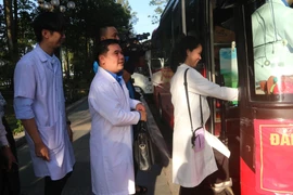 Các nhân viên y tế tỉnh Đồng Nai nhanh chóng lên xe khởi hành đi hỗ trợ bà con vùng lũ khắc phục hậu quả thiên tai. (Ảnh: Lê Xuân/TTXVN)