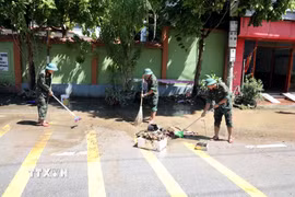 Các cán bộ chiến sỹ Bộ Chỉ huy Quân sự tỉnh Lạng Sơn giúp người dân Thất Khê dọn dẹp vệ sinh. (Ảnh: Văn Đạt/TTXVN)
