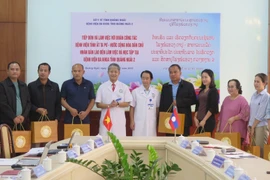 Lãnh đạo Bệnh viện Đa khoa tỉnh Quảng Ngãi 2 tặng quà cho lãnh đạo Bệnh viện tỉnh Attapeu. (Ảnh: Dư Toán/TTXVN)