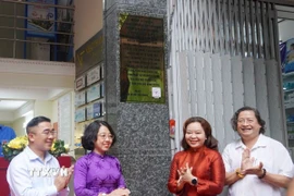 Các đại biểu thực hiện nghi thức ra mắt bảng hiệu Di tích Lịch sử cấp Quốc gia Trụ sở báo Dân Chúng. (Ảnh: Thu Hương/TTXVN)