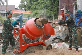 Cán bộ, chiến sỹ Ban Chỉ huy phòng thủ Khu vực 2 - Diên Khánh (Bộ Chỉ huy Quân sự tỉnh Khánh Hòa) giúp gia đình bà Lê Thị Tuyết (phường Nam Nha Trang, tỉnh Khánh Hòa) xây dựng nhà mới. (Ảnh: Xuân Triệu/TTXVN)