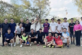 Đại sứ Lê Quang Long và phu nhân Nguyễn Thị Ngọc Thư chụp ảnh cùng các cầu thủ thi đấu. (Ảnh: Việt Hùng/TTXVN)