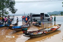 Nhiều người dân vùng lũ lụt chọn ghe, xuồng làm phương tiện đi lại trong mưa lũ. (Ảnh: Hải Âu/TTXVN)