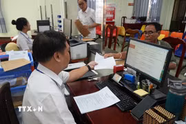 Giải quyết hồ sơ, thủ tục hành chính cho người dân và doanh nghiệp tại Trung tâm phục vụ hành chính công phường Rạch Giá (An Giang). (Ảnh: Lê Huy Hải/TTXVN)