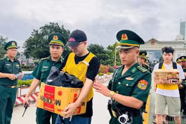 Bàn giao nhóm đối tượng cho Công an Trung Quốc. (Nguồn: Báo Lào Cai)