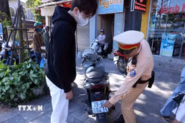 Các trường hợp dán, che biển số khi tham gia giao thông được yêu cầu khôi phục tình trạng ban đầu. (Ảnh: Phạm Kiên/TTXVN)