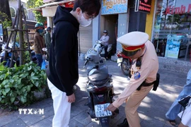 Các trường hợp dán, che biển số khi tham gia giao thông được yêu cầu khôi phục tình trạng ban đầu. (Ảnh: Phạm Kiên/TTXVN)