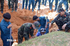 Toàn bộ khu vực vị trí các phần mộ được khoanh vùng, đánh dấu kỹ lưỡng trước khi tiến hành quy tập. (Ảnh: Hồng Hiếu/TTXVN)