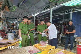 Cơ quan chức năng lấy mẫu thịt lợn bày bán tại chợ xã Vĩnh Viễn, thành phố Cần Thơ sau khi phát hiện 1 con lợn nhiệm virus tả châu Phi được đưa ra chợ này tiêu thụ. (Ảnh: TTXVN phát)