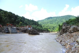 Nước lũ cuốn trôi nhịp cầu Xốp Chạng trên quốc lộ 48C, làm biến dạng hoàn toàn lòng suối khu vực hai bên cầu. (Ảnh: Xuân Tiến/TTXVN)