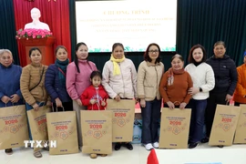 Cán bộ, nhân viên Văn phòng TTXVN với các gia đình được nhận quà tặng. (Ảnh: Quang Cường/TTXVN)