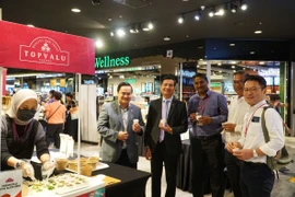 Đại sứ Đinh Ngọc Linh (thứ hai từ bên trái), Tham tán Lê Phú Cường (ngoài cùng bên trái) cùng lãnh đạo Tập đoàn AEON Malaysia tại quầy phở trộn do AEON chế biến. (Ảnh: Hằng Linh/TTXVN)