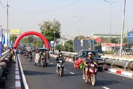 Các phương tiện lưu thông qua cầu Bình Phước 1 trên Quốc lộ 1. (Ảnh: Tiến Lực/TTXVN)