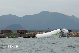 Lực lượng cứu trợ khẩn cấp làm nhiệm vụ tại hiện trường vụ máy bay chở hàng trượt khỏi đường băng và lao một phần xuống biển ở sân bay quốc tế Hong Kong, Trung Quốc ngày 20/10/2025. (Ảnh: REUTERS/TTXVN)