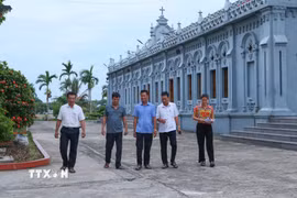 Cán bộ xóm 2, xã Nghĩa Sơn, Ninh Bình tới nhà thờ trên địa bàn để tuyên truyền, vận động người dân đồng thuận với chủ trương sắp xếp, tổ chức lại thôn, tổ dân phố. (Ảnh: Công Luật/TTXVN)