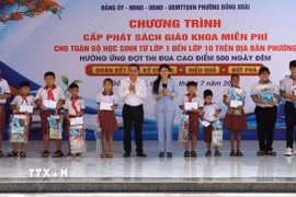 Ủy viên Trung ương Đảng, Phó Bí thư Thường trực Thành ủy, Chủ tịch HĐND thành phố Đông Nai Tôn Ngọc Hạnh và lãnh đạo phường Đồng Xoài tặng quà và sách giáo khoa cho học sinh có hoàn cảnh khó khăn. (Ảnh: Nhật Bình/TTXVN)