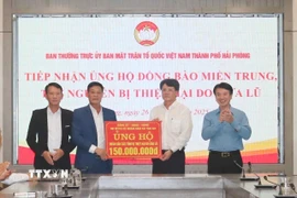Đại diện Thường trực Đảng ủy và Ủy ban Mặt trận Tổ quốc Việt Nam xã Tân An (bên trái) chuyển tới Mặt trận Tổ quốc Việt Nam thành phố Hải Phòng 150 triệu đồng do nhân dân xã Tân An đóng góp, để ủng hộ đồng bào miền Trung - Tây Nguyên. (Ảnh: Mạnh Minh/TTXVN)