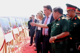 Lãnh đạo Bộ Quốc phòng Việt Nam cùng Đại sứ Đặc mệnh toàn quyền Hợp chúng quốc Hoa Kỳ tại Việt Nam Marc Evans Knapper và đại diện các cơ quan, tổ chức quốc tế tham triển lãm tại sự kiện. (Ảnh: Sỹ Tuyên/TTXVN)