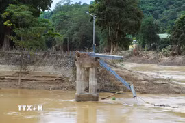 Chân cầu treo Đền Vạn và hệ thống trụ cáp còn sót lại sau trận lũ lịch sử xảy ra vào tối 22 và rạng sáng ngày 23/7/2025. (Ảnh: Xuân Tiến/TTXVN)